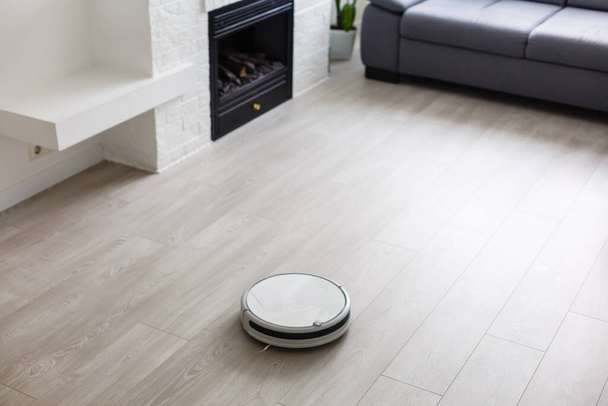 robotic vacuum cleaner on laminate wood floor smart cleaning technology - Photo, Image