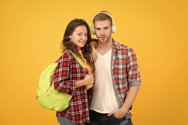 Youth lead way in fashion ideas. Hipster couple students. Fashionable students couple yellow background. Modern couple wearing matching outfits. Family look concept. Shopping day. Trendsetters - Fotó, kép