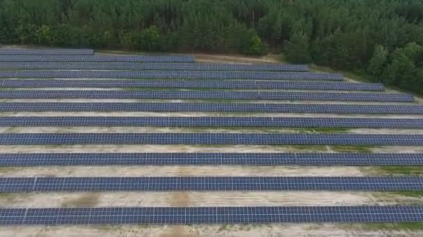 フィールドに設置された太陽光パネルステーションは、太陽エネルギーを収集し、電気に変換します。環境に優しい電気エネルギー. - 映像、動画