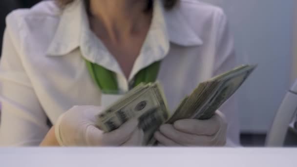 Teller Counting Dollars in Protective Gloves. Bank Employee Recounts Cash in One Hundred Dollar Bills. Cashier Recounts American Banknotes in Currency Exchange Office. Bank Cash Department. Finances - Footage, Video