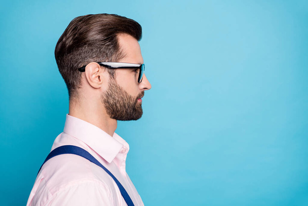 Closeup profile photo of handsome business man successful young chief boss worker look empty space serious facial expression wear specs pink shirt suspenders isolated blue color background - Фото, зображення
