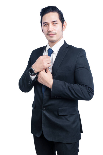 Asian businessman standing with hand on tie isolated over white background - Foto, afbeelding