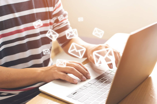 Koncepcja e-mail marketingu i newslettera. Ręka człowieka wysyłanie wiadomości i laptopa z ikoną e-mail - Zdjęcie, obraz