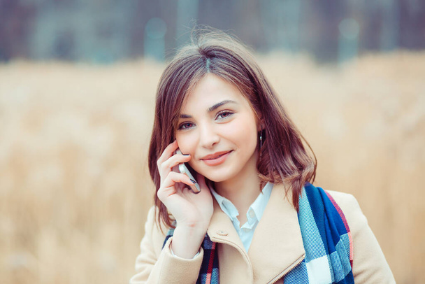 Phone talk. Closeup portrait. Happy woman talking on mobile phone outside outdoors on autumn park background, professional conversation, smart business people concept - Foto, afbeelding