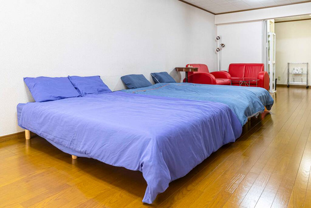 Duże łóżko podwójne i niebieska narzuta w sypialni mieszkania - Zdjęcie, obraz