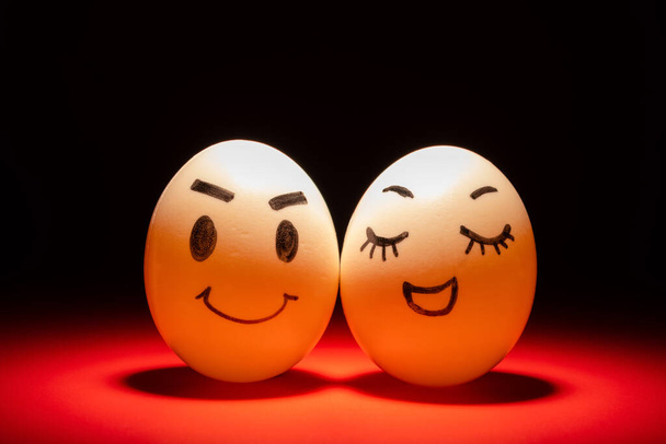 caras de huevo de pareja encantadora resaltado en la oscuridad - Foto, Imagen