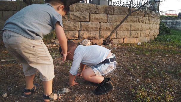 Lindo 4 años de edad ayudando a su hermano a limpiar la rodilla después de que se sintió abajo. Hermanos cuidándose unos a otros - Foto, Imagen