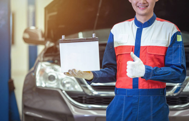 Técnico de mano cercano o mecánico auto Asegurando la batería del coche en el centro de servicio del coche de la reparación auto. - Foto, Imagen