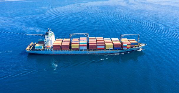 Container cargo ship full loaded, import export business and logistics, aerial view. Water transport, international freight shipping, commercial trade and transportation in the open sea - Photo, Image