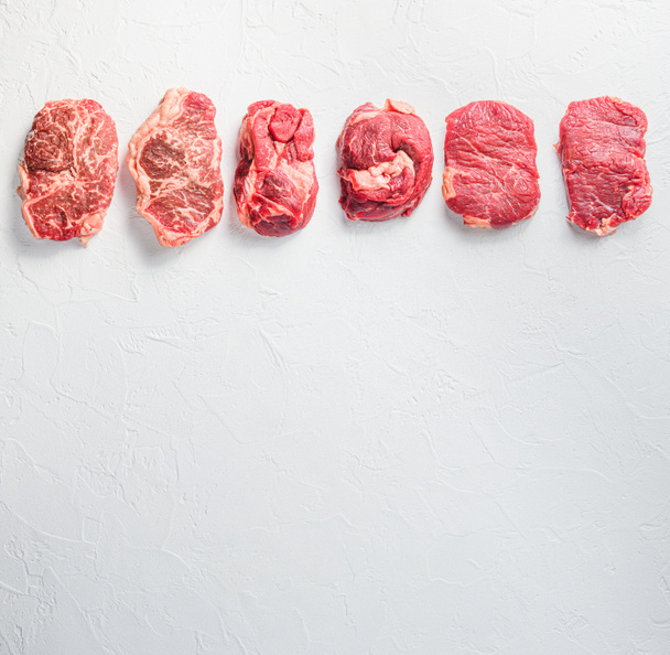 Rraw beef steaks set top blade, rump, chuck eye roll over white concrete background, top view space for text - Photo, Image