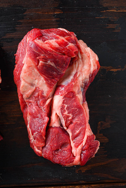 Roh Rindfleisch Chuck Roll Steaks auf alten hölzernen dunklen Planken Draufsicht - Foto, Bild