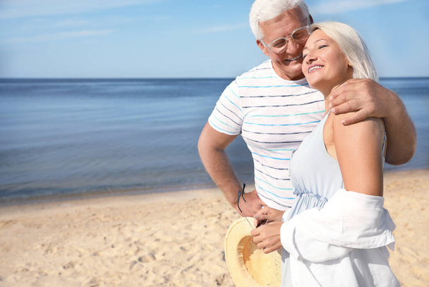 Зрелая пара проводит время вместе на морском пляже - Фото, изображение
