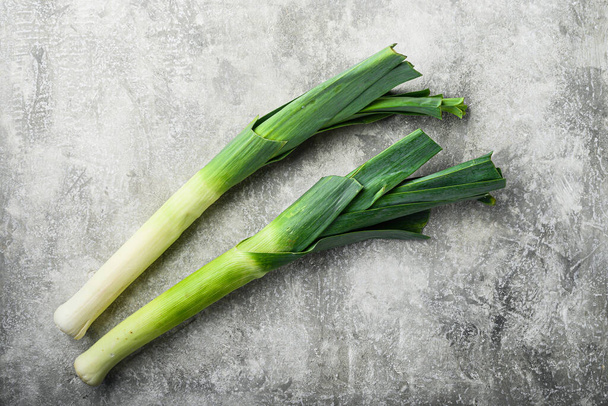 Organic Leek onion on grey textured background, top view with space for text - Foto, afbeelding