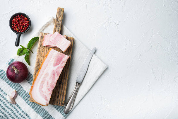 Bacon pancetta cut and sliced with herbs on white background, top view with space for text. - Fotoğraf, Görsel