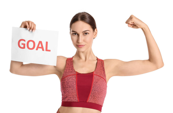 Sportovní žena drží papír s textem GOAL na bílém pozadí - Fotografie, Obrázek