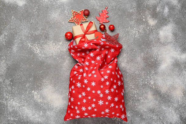 Weihnachtsmann-Tasche mit Geschenken und Dekor auf grauem Hintergrund - Foto, Bild