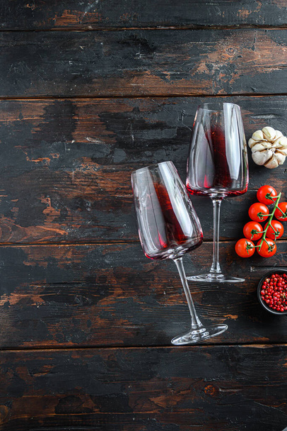 Два бокала красного вина на темно-деревянном фоне, вид сверху с пространством для текста - Фото, изображение