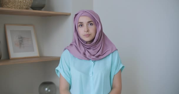 Een vrouw in een hijab kijkt in de camera en knikt stilletjes met haar hoofd en luistert. Gesprek via videolink. Videoconferentie luisteren naar de aanbevelingen van de artsen.  - Video