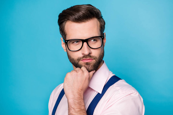 Closeup photo of handsome business man trend clothes hold arm on chin seriously look side empty space have creative idea wear specs pink shirt suspenders isolated blue color background - Photo, Image