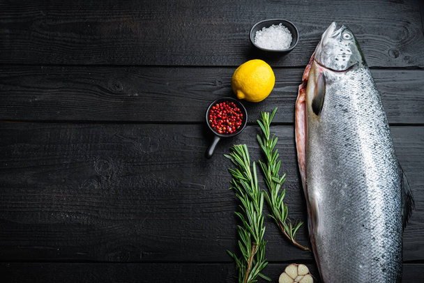 Čerstvý syrový losos červený rybí filet na černém dřevěném povrchu s prostorem pro text. - Fotografie, Obrázek