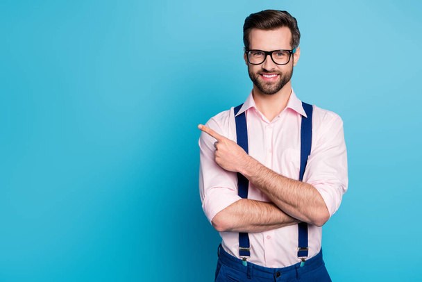 Photo of handsome business man good mood trend clothes guy beaming smile eyesight vision specs direct finger side empty space wear pink shirt suspenders isolated blue color background - Fotoğraf, Görsel