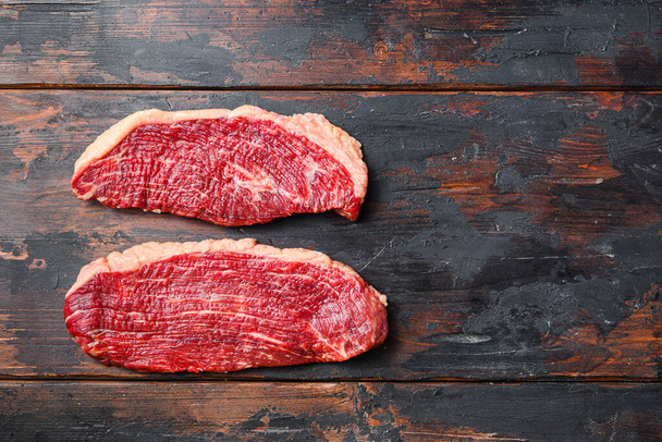 Bir çift organik picanha bifteği, koyu eski ahşap arka planda, metin için geniş manzaralı. - Fotoğraf, Görsel