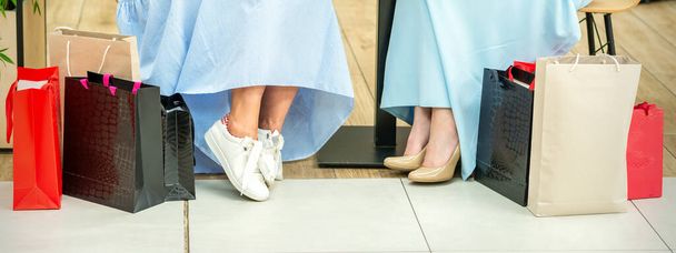 Περικοπή πλάνο των γυναικείων ποδιών με τσάντες ψώνια στο καφέ του εμπορικού κέντρου - Φωτογραφία, εικόνα