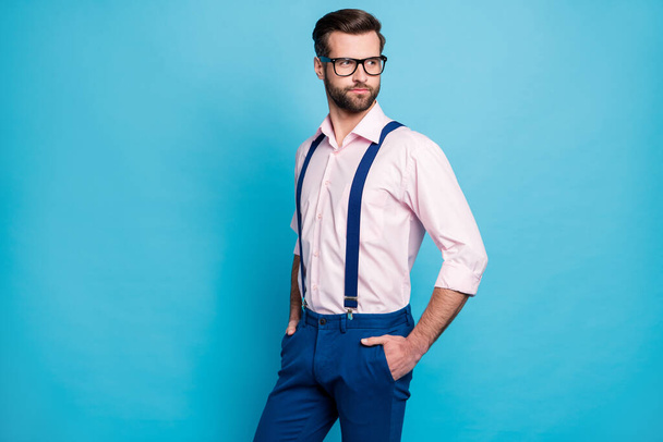 Photo of handsome macho business man cool clothes guy eyesight care vision specs look side empty space wear pink shirt suspenders pants isolated pastel blue color background - Valokuva, kuva