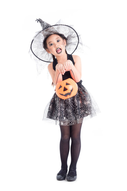 Full length of asian girl in halloween costume holding pumpkin bucket over white background. - Фото, зображення