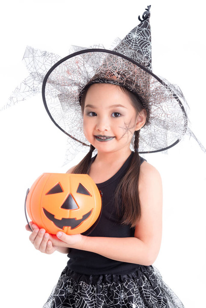 Söpö aasialainen tyttö halloween puku tilalla kurpitsa ämpäri hymyilee valkoisella taustalla. - Valokuva, kuva