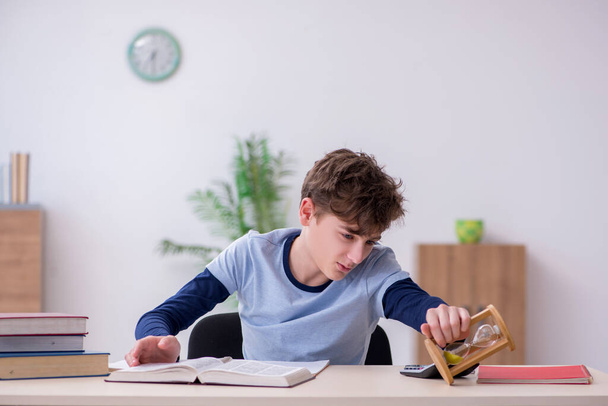 Schoolboy preparing for exams in time management concept - Foto, afbeelding