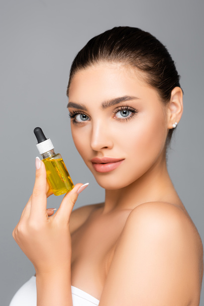 woman holding bottle with serum isolated on grey - Foto, Imagen