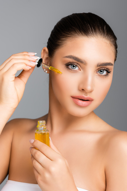 woman applying serum on face isolated on grey - Photo, Image