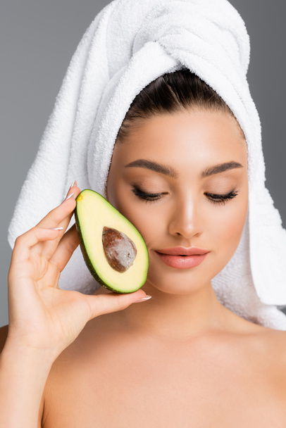 woman with towel on head and avocado isolated on grey - Zdjęcie, obraz