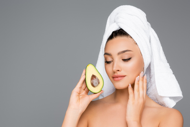 woman with towel on head and avocado isolated on grey - Foto, Imagen