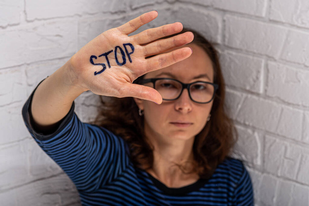 The woman shows the inscription STOP on her palm. Domestic Violence. - Fotoğraf, Görsel
