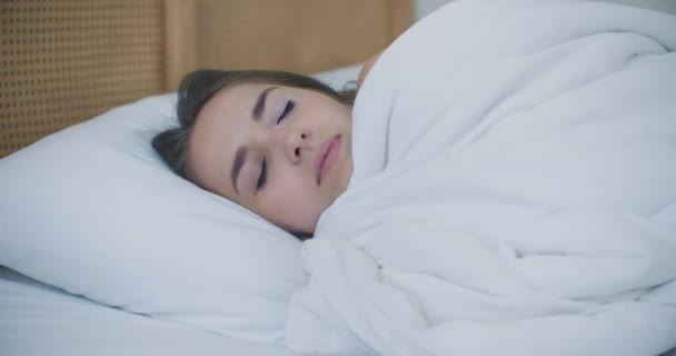 Aantrekkelijke brunette vrouw in pyjama liggend in bed slapeloos, slapeloosheid. - Video
