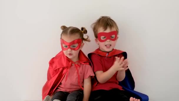 Drôle garçon et fille en costumes de super-héros applaudissent mains - Séquence, vidéo