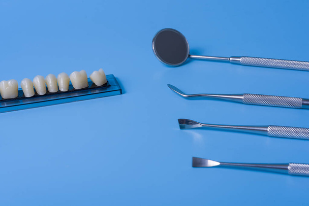 Zahnmodell mit Zahnwerkzeugen auf blauem Hintergrund. Konzept der Zahnmedizin und Zahngesundheit. - Foto, Bild