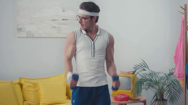 Frontansicht lustiger Sportler beim Gewichtheben im Wohnzimmer, Retro-Sportkonzept - Filmmaterial, Video