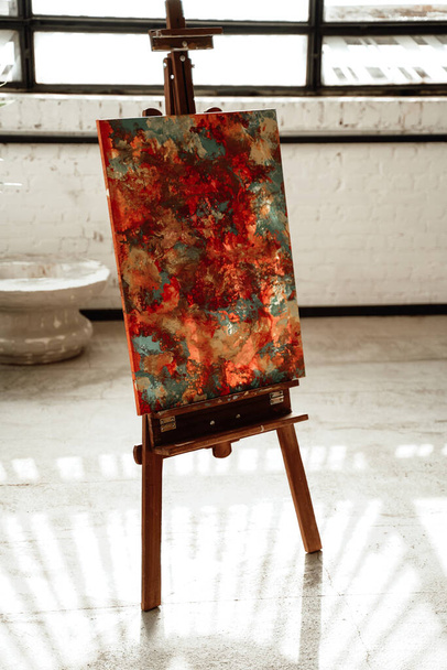 Isolated easel with modern abstract art in studio room - Foto, immagini