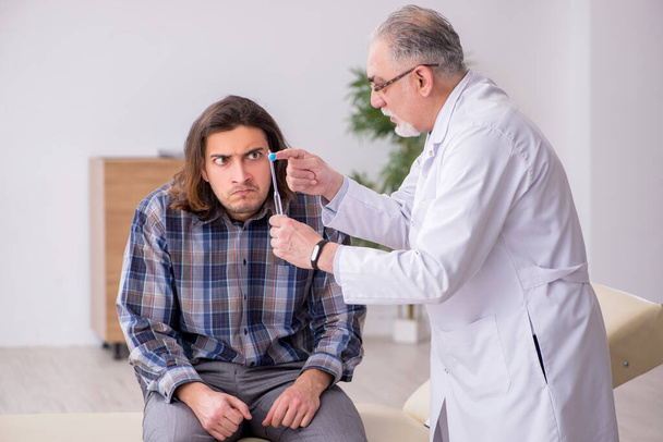 Fiatal férfi beteg látogató tapasztalt orvos neurológus - Fotó, kép
