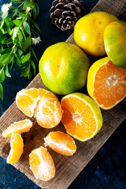 Fruits mûrs Mandarine pelé ouvert et placer sur vieux bois aspect rustique avec groupe de fruits et de feuilles de mandarine. Fruits d'hiver. - Photo, image