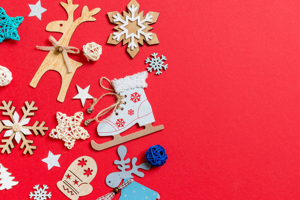 Top view of holiday toys and decorations on red Christmas background. New Year time concept with copy space. - Photo, image