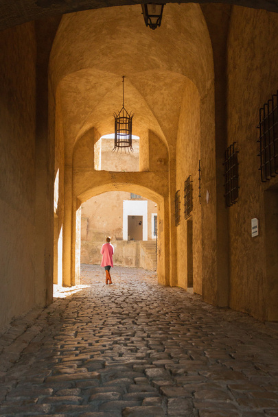 Mulher caminhando pela entrada da cidadela em Calvi, Cors
 - Foto, Imagem