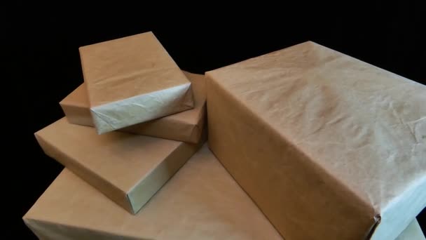 Подарочные коробки упакованы крафтовой бумагой. Несколько коробок разных размеров завернуты в обычную бумагу. Отойди влево.. - Кадры, видео