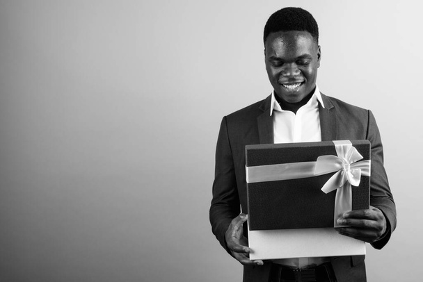 Studio záběr mladého afrického podnikatele v obleku proti bílému pozadí v černé a bílé - Fotografie, Obrázek