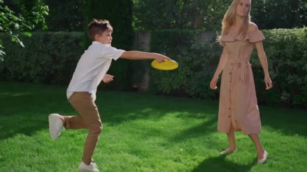 Ένας έφηβος ρίχνει ιπτάμενο δίσκο στην αδερφή του στο πάρκο. Χαριτωμένο κορίτσι πιάνοντας δίσκο - Πλάνα, βίντεο