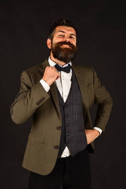 Businessman with beard adjusting his bow tie - Foto, Imagem
