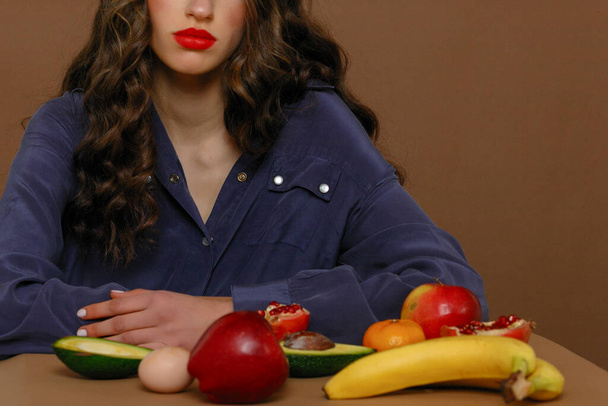 Young woman in group of fruit. Healthcare and healthy nutrition concept. Red lipstick - Fotó, kép